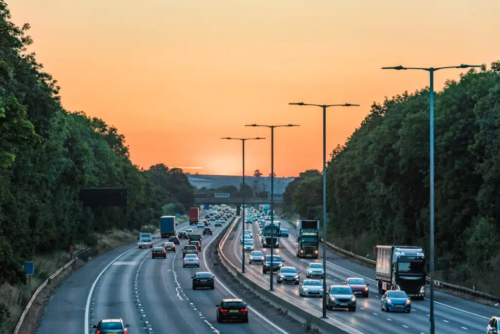How to Travel From London to Manchester Sunset view of busy UK motorway traffic in England.